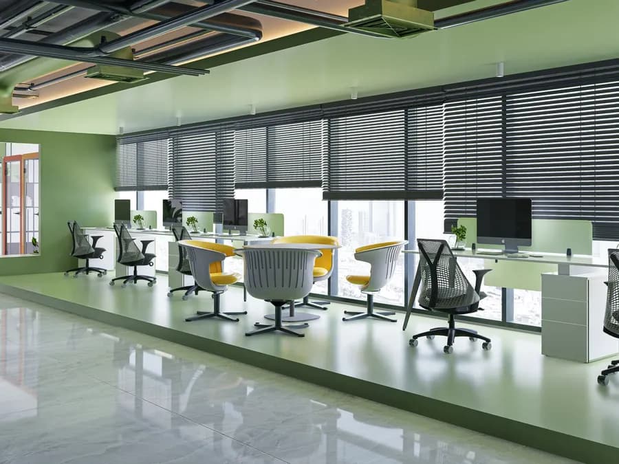 Office meeting area with yellow accent wall and modern workstations